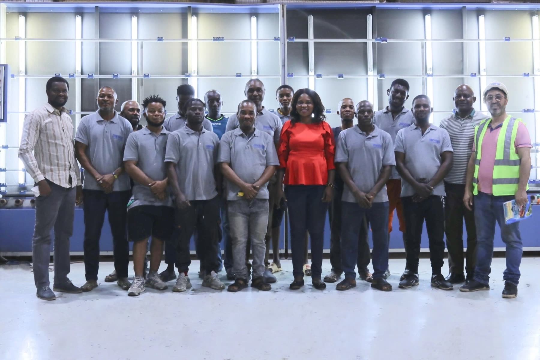 The Euro Decor team in their blue uniforms, in front of the factory's glass racks